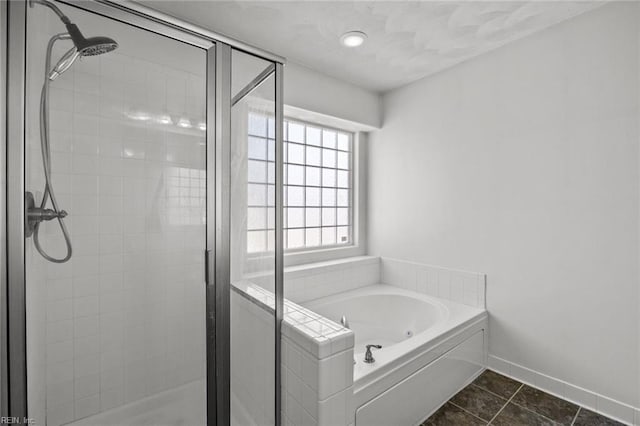 bathroom featuring tile patterned floors, a shower stall, baseboards, and a garden tub