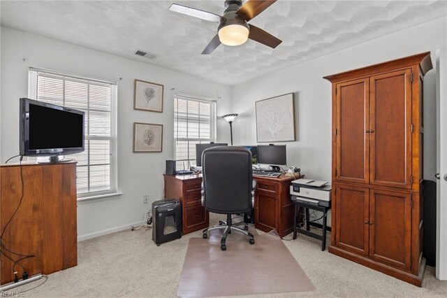 office space with baseboards, visible vents, ceiling fan, a textured ceiling, and light colored carpet