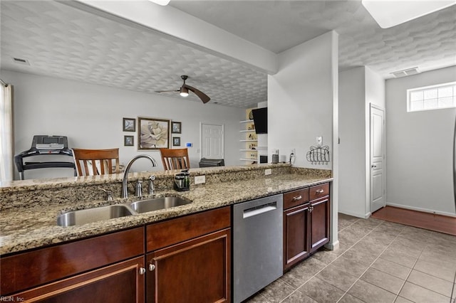 kitchen featuring a ceiling fan, light stone countertops, visible vents, a sink, and stainless steel dishwasher