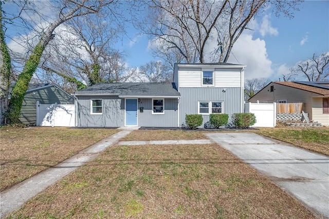 traditional home with a front lawn and fence