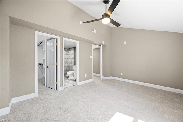 unfurnished bedroom featuring lofted ceiling, a spacious closet, visible vents, and carpet floors