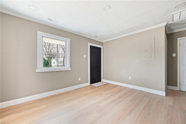 spare room featuring crown molding, baseboards, visible vents, and light wood-type flooring