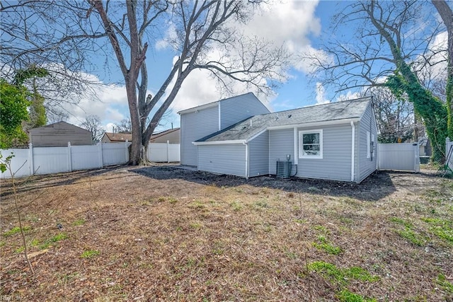 rear view of house featuring central air condition unit and a fenced backyard