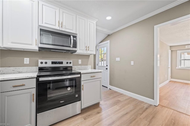 kitchen featuring a wealth of natural light, light wood finished floors, and appliances with stainless steel finishes