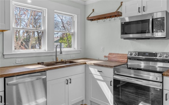 kitchen featuring a sink, open shelves, appliances with stainless steel finishes, white cabinets, and butcher block counters