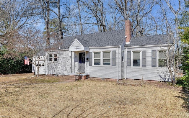 view of front facade featuring crawl space, a chimney, roof with shingles, and a front lawn