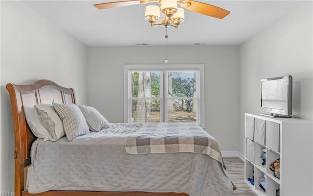 bedroom featuring ceiling fan, visible vents, and wood finished floors