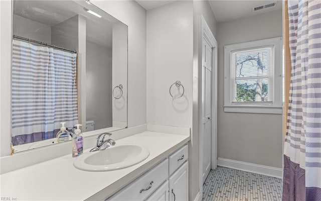 full bath featuring vanity, tile patterned floors, baseboards, and visible vents