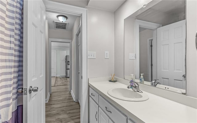 full bathroom featuring visible vents, wood finished floors, and vanity