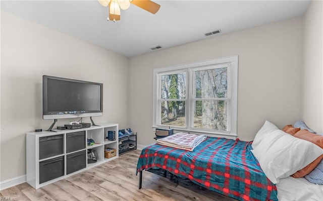 bedroom featuring visible vents, baseboards, light wood-style flooring, and a ceiling fan