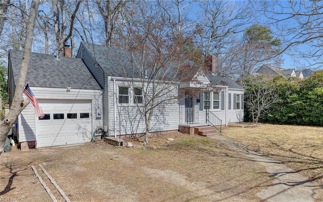 view of front facade featuring roof with shingles, a garage, driveway, and a chimney