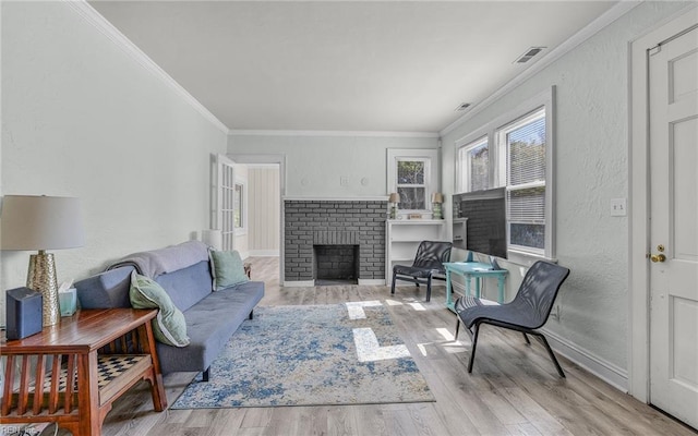 living area with visible vents, wood finished floors, a fireplace, crown molding, and a textured wall