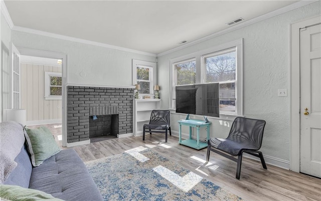 living area featuring wood finished floors, a textured wall, and ornamental molding