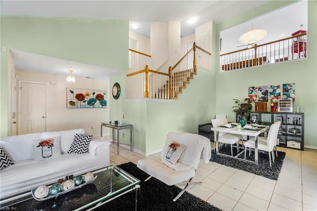 living room featuring stairway, baseboards, a high ceiling, and tile patterned flooring