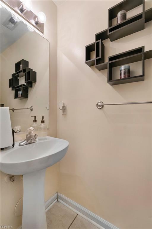 bathroom featuring a sink, baseboards, and tile patterned flooring