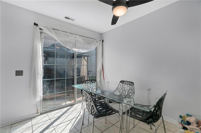 dining space featuring tile patterned flooring, visible vents, baseboards, and ceiling fan