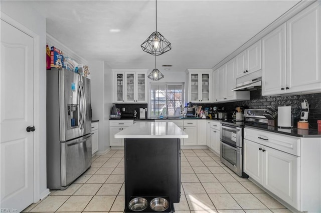 kitchen featuring under cabinet range hood, tasteful backsplash, appliances with stainless steel finishes, and light tile patterned flooring