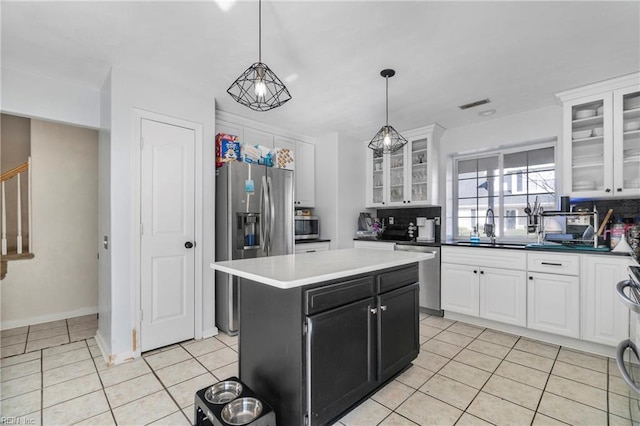 kitchen featuring light tile patterned floors, visible vents, a sink, stainless steel appliances, and white cabinetry