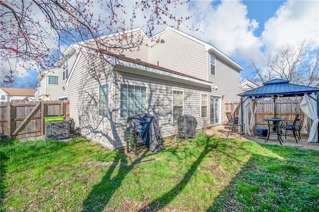 rear view of house featuring a gazebo, a fenced backyard, a yard, a patio, and a gate