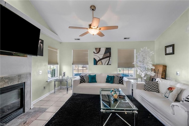 living room featuring light tile patterned flooring, visible vents, a fireplace, and lofted ceiling