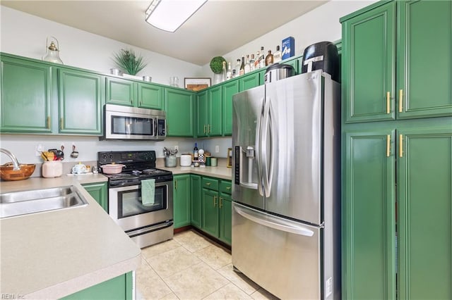 kitchen with a sink, light countertops, light tile patterned flooring, and stainless steel appliances