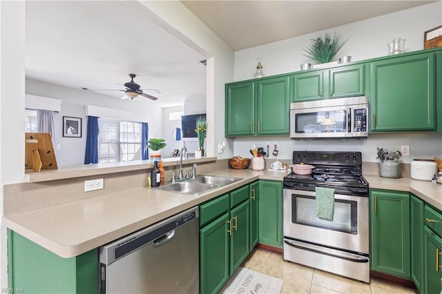 kitchen featuring a ceiling fan, a sink, appliances with stainless steel finishes, a peninsula, and light countertops