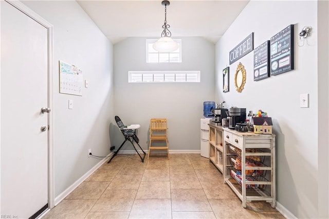 interior space featuring light tile patterned floors, baseboards, and vaulted ceiling