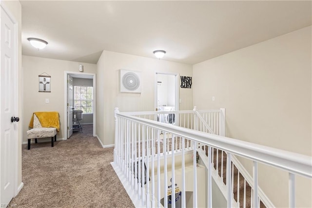 hall featuring carpet, an upstairs landing, and baseboards