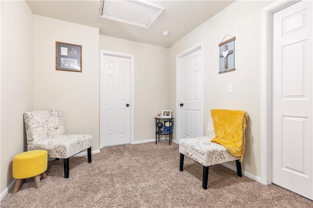 living area featuring light colored carpet, attic access, and baseboards