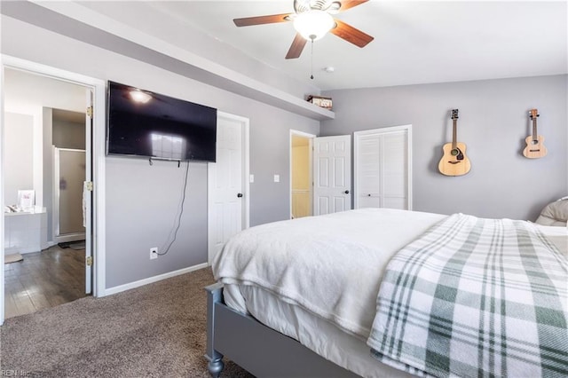 carpeted bedroom featuring lofted ceiling, baseboards, two closets, and ceiling fan