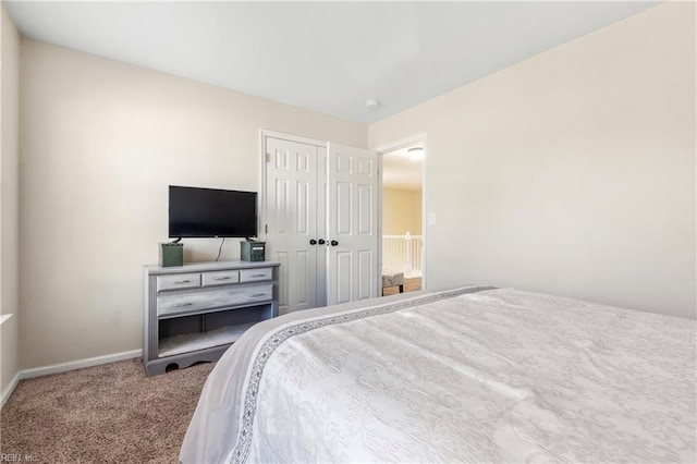 carpeted bedroom featuring baseboards and a closet