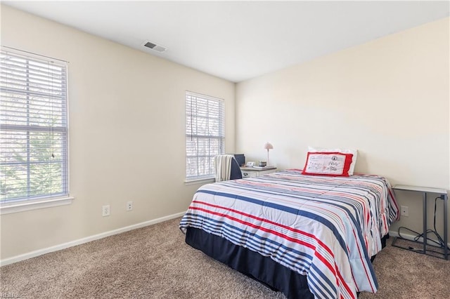 bedroom with multiple windows, carpet flooring, baseboards, and visible vents