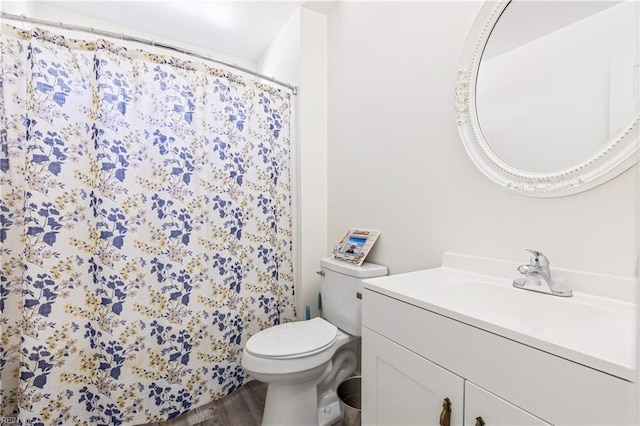 bathroom with vanity, a shower with shower curtain, toilet, and wood finished floors