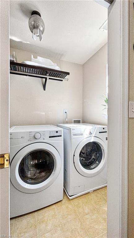 washroom with washer and clothes dryer, laundry area, and light tile patterned floors