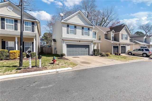 traditional-style home featuring an attached garage, fence, a residential view, and driveway