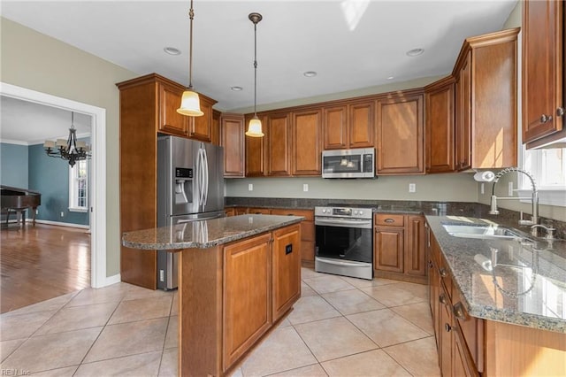 kitchen with a sink, brown cabinets, appliances with stainless steel finishes, and light tile patterned floors