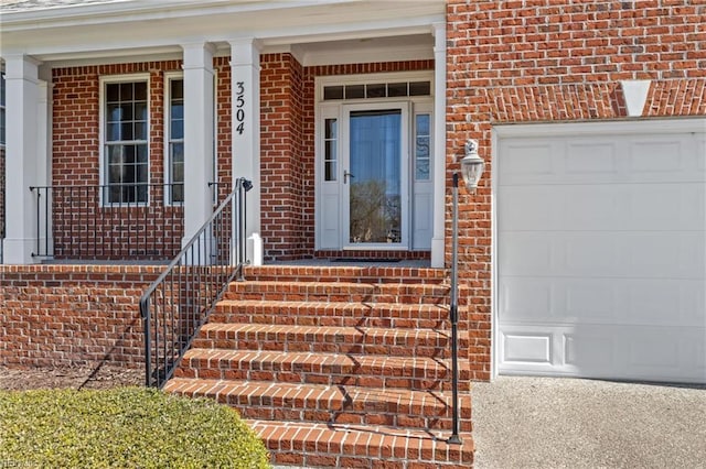 view of exterior entry featuring brick siding and an attached garage