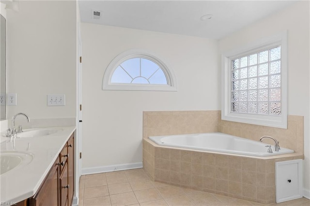 bathroom featuring tile patterned floors, visible vents, a bath, and a sink