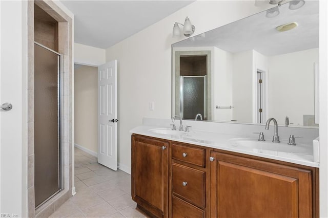 bathroom featuring tile patterned floors, a shower stall, double vanity, and a sink