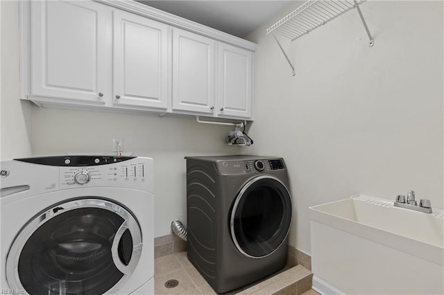 laundry room with light tile patterned floors, baseboards, cabinet space, a sink, and washing machine and dryer