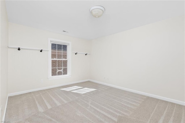 carpeted empty room featuring visible vents and baseboards