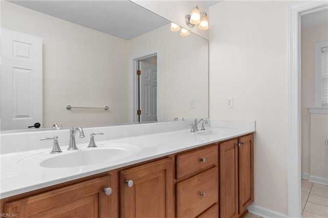 bathroom with tile patterned flooring, double vanity, baseboards, and a sink