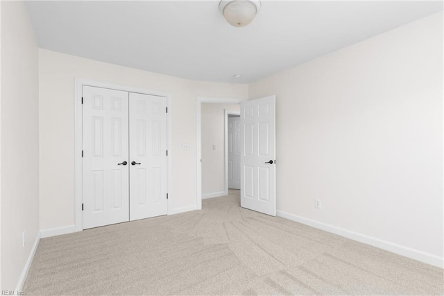 unfurnished bedroom featuring a closet, baseboards, and carpet