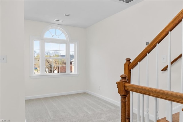 stairs with visible vents, carpet flooring, and baseboards