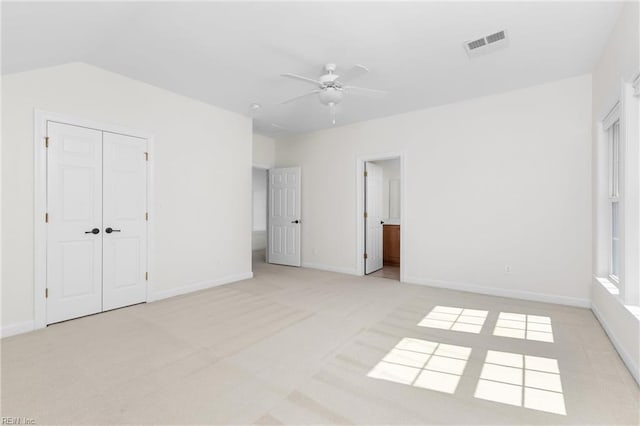 unfurnished bedroom with visible vents, light carpet, a closet, baseboards, and ceiling fan