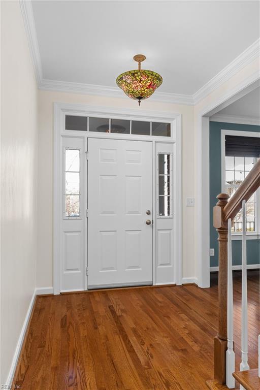 entrance foyer with plenty of natural light, wood finished floors, and ornamental molding