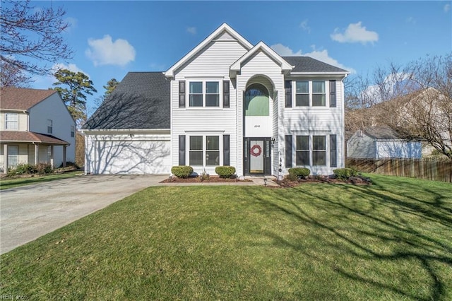 traditional-style house featuring driveway, an attached garage, a front yard, and fence