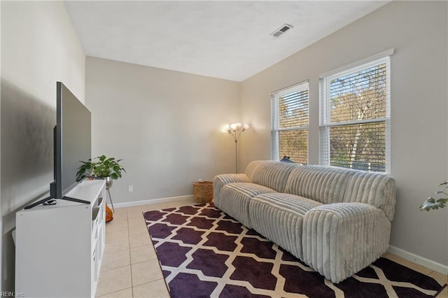 living room with light tile patterned floors, visible vents, and baseboards