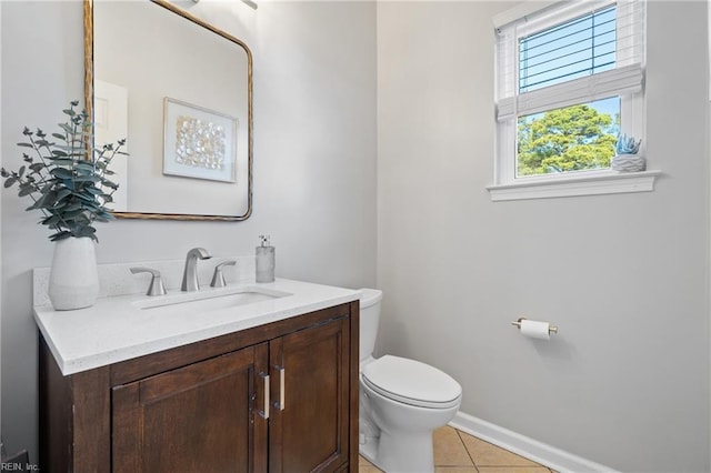 bathroom featuring tile patterned floors, baseboards, toilet, and vanity