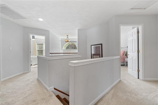 corridor featuring visible vents, an upstairs landing, carpet, and baseboards